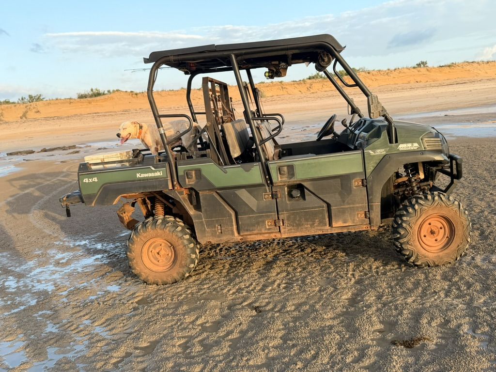 A muddy side-by-side buggy on the sand at low tide, Dundee Beach