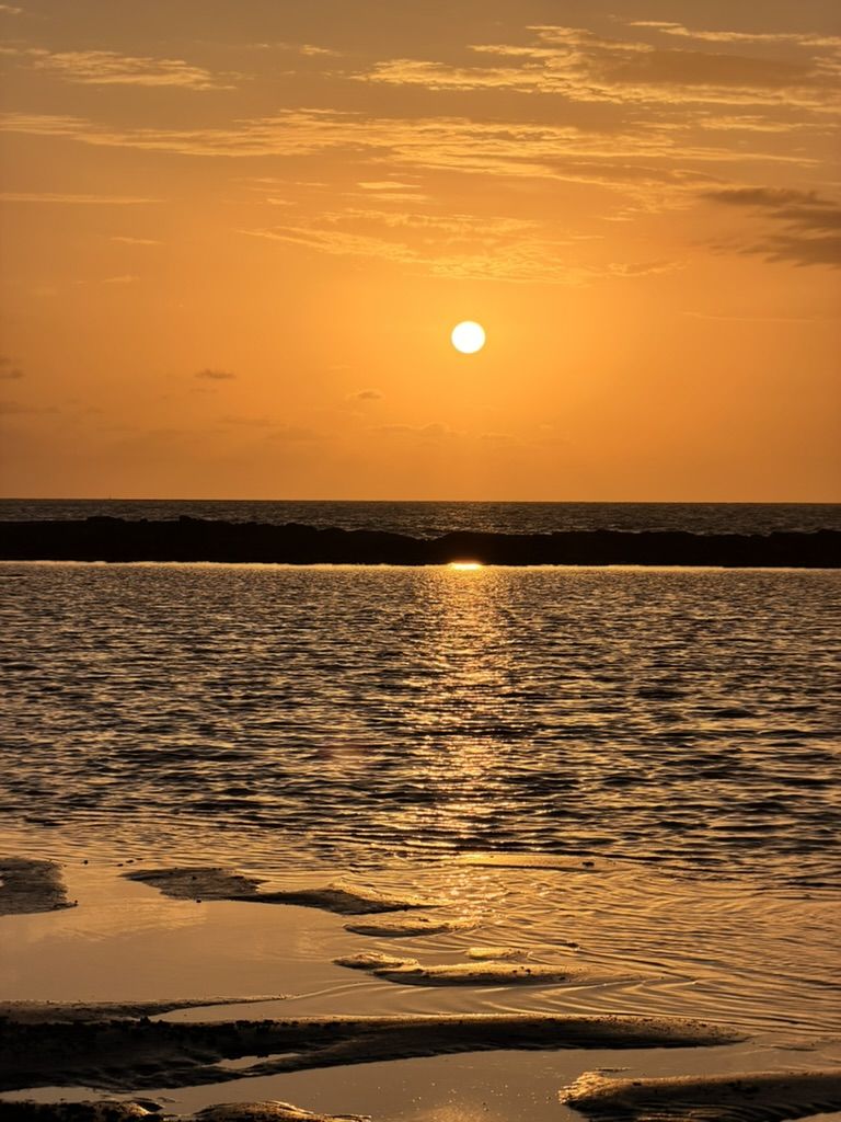 Orange sun dropping into the sea at Dundee Beach