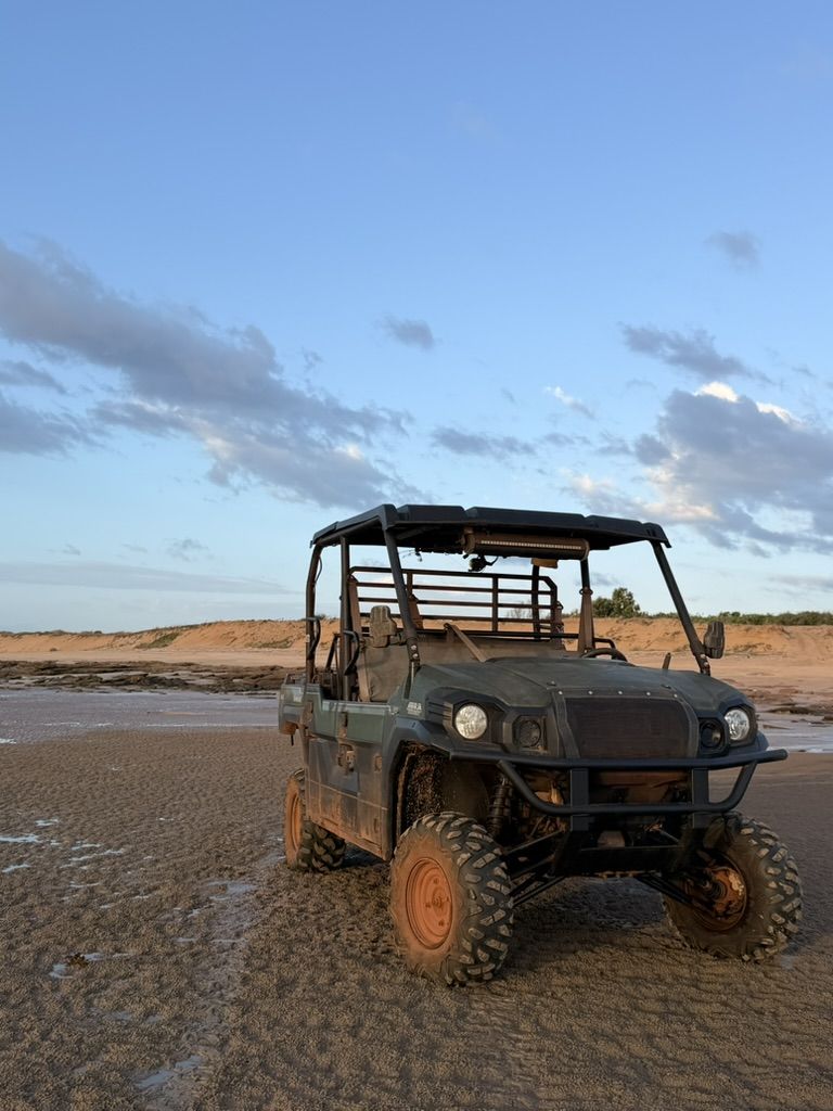 A side-by-side buggy on the Dundee flats under a blue sky